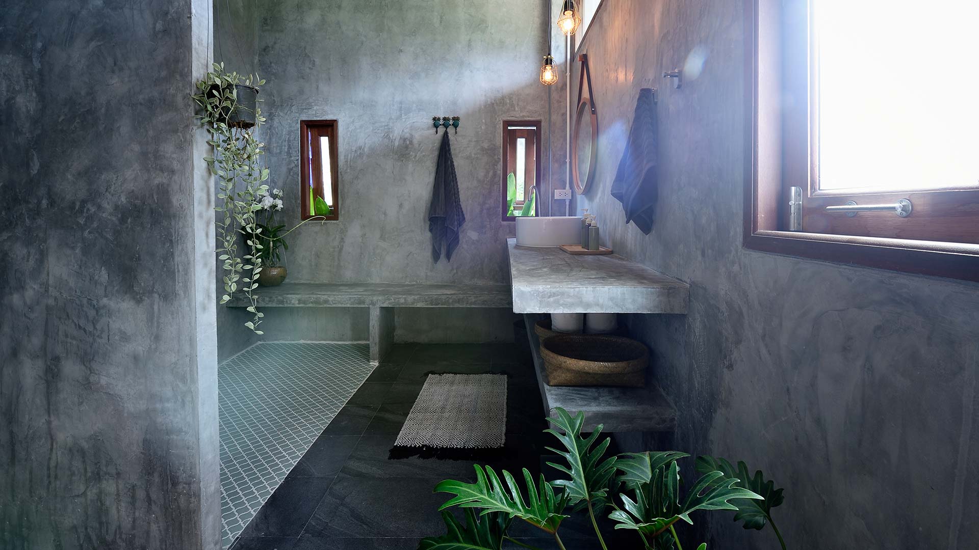 Ett badrum med gråa väggar i microcement