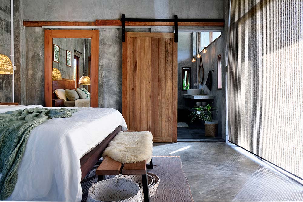 Ett ljust modernt sovrum med gråa väggar i microcement